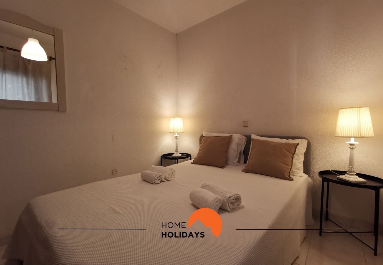 Quarto com cama de casal e duas mesas de suporte