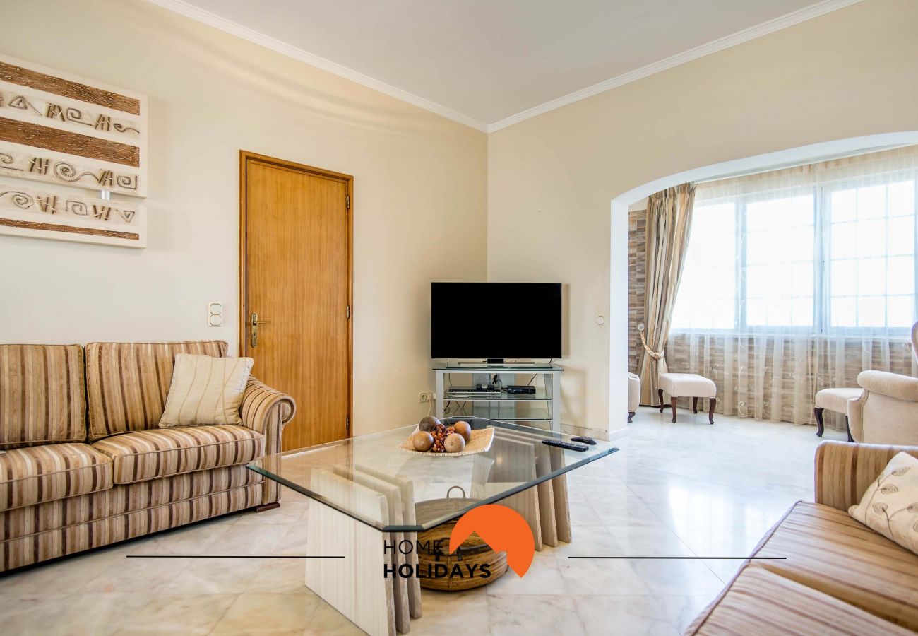 Sala de estar com sofás e ecrã plano