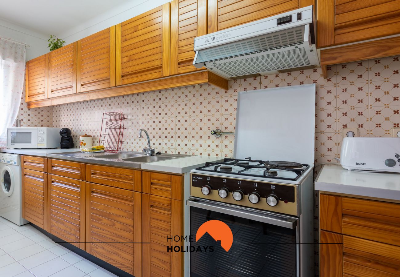 Cozinha equipada com fogão, forno, microondas e máquina de roupa