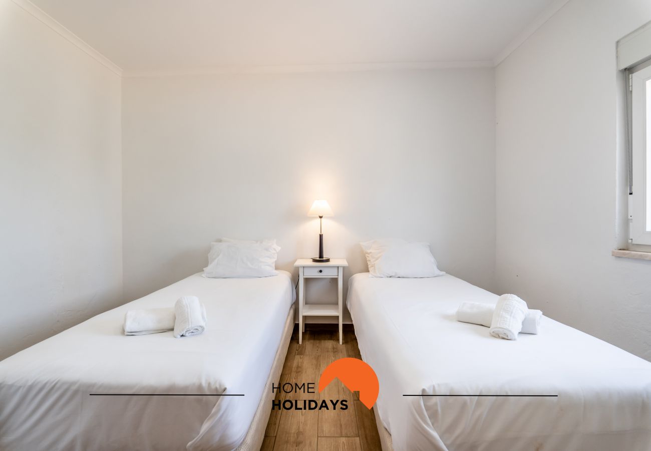 Quarto com camas individuais, mobília branca, decoração minimalista